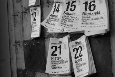 Hojas de calendario colgadas en pared en blanco y negro que muestran números grandes y sugieren la interpretacion del numero significado y simbolismo.