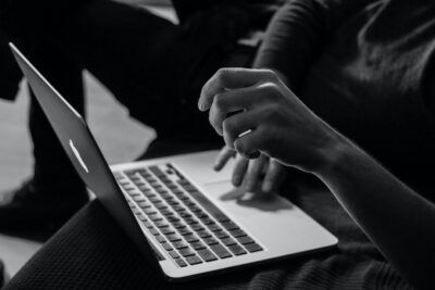 Persona usando un portátil buscando los mejores sitios web jugar ajedrez en linea amigos
