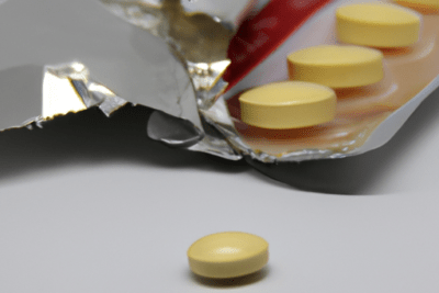 Blíster abierto con comprimidos amarillos y uno suelto — medicina caducada que debes saber