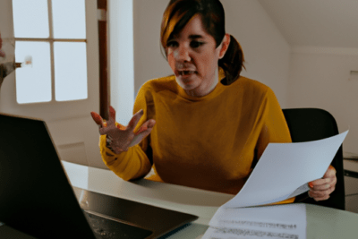 Persona preocupada frente a un portátil y varios documentos revisando opciones porque mi certificado digital ha caducado que debo hacer