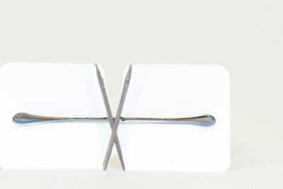 Sujetatarjetas metálico en forma de X sosteniendo dos tarjetas blancas, nie caducado todo lo que necesitas saber
