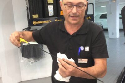 Persona sosteniendo la varilla para medir el nivel aceite del motor