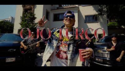 Cartel de video urbano ojo turco con cantante en primer plano, banda y coches de fondo