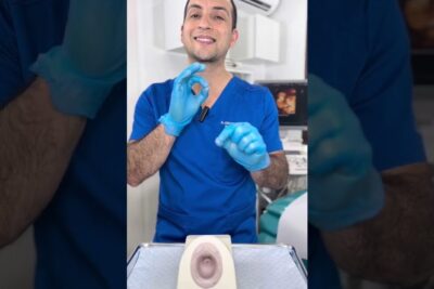 Profesional sanitario con guantes explicando ovulo deshace frente a un modelo anatómico