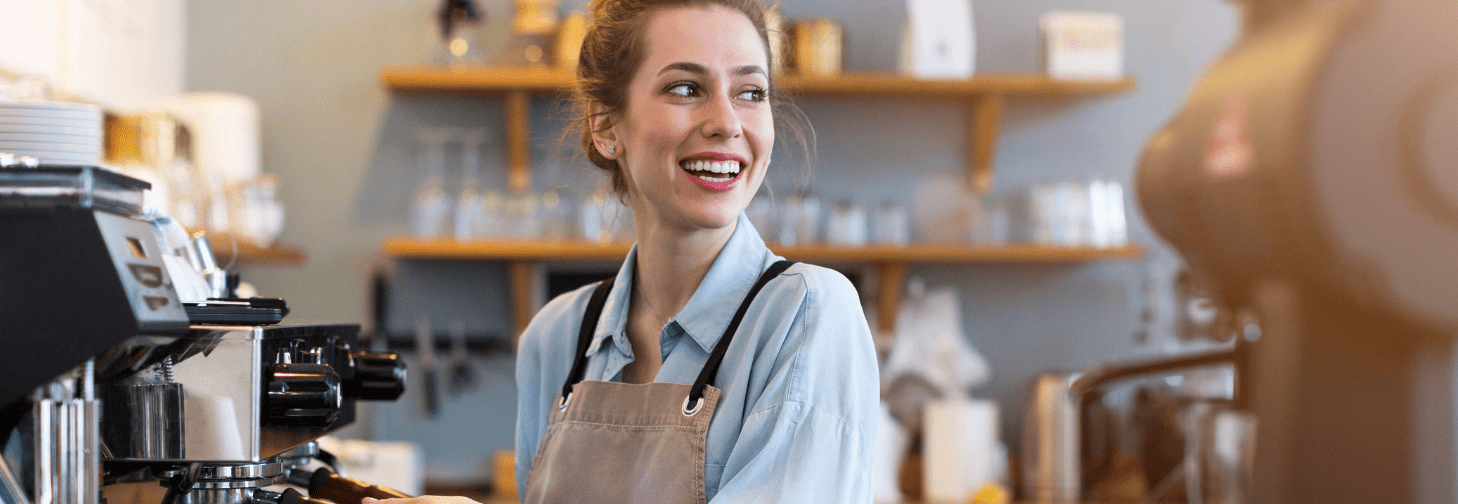 Barista sonriente preparando café en una cafetería que consecuencias tiene faltar un dia al trabajo en costa rica