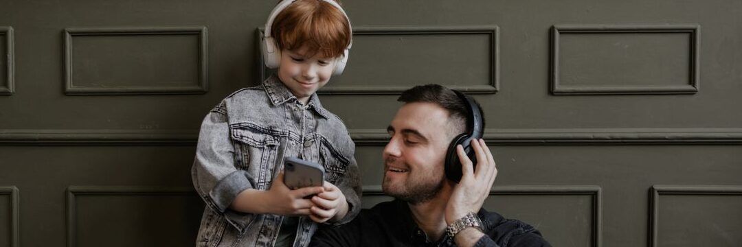Padre e hijo sonrientes con auriculares y teléfono, que consecuencias tiene no cumplir con el regimen de visitas judiciales