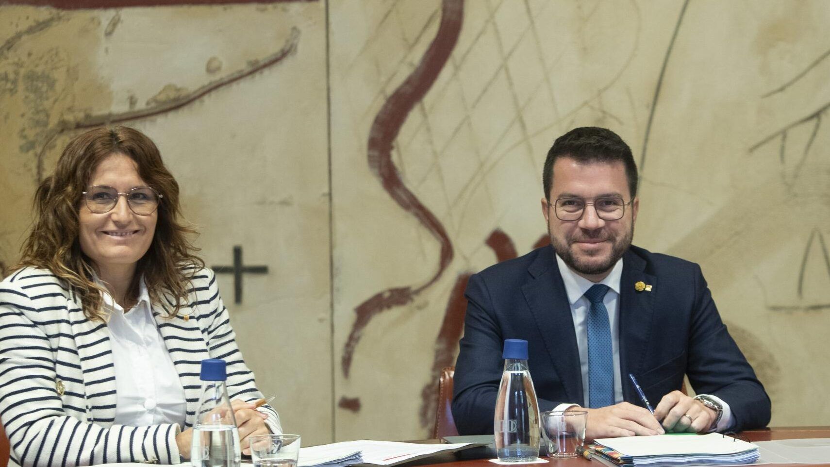 Dos personas sentadas en una mesa con documentos y botellas de agua, que consecuencias tiene una declaracion negativa de la generalitat 2