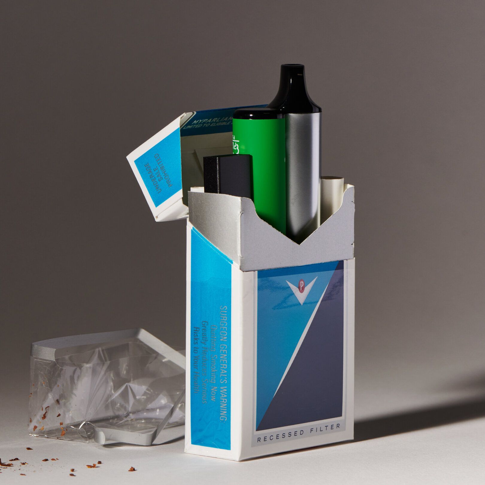 Cajetilla abierta que contiene un vapeador verde y accesorios junto a restos de tabaco que efectos tiene fumar 1 cigarrillo al mes descubre la verdad con zero