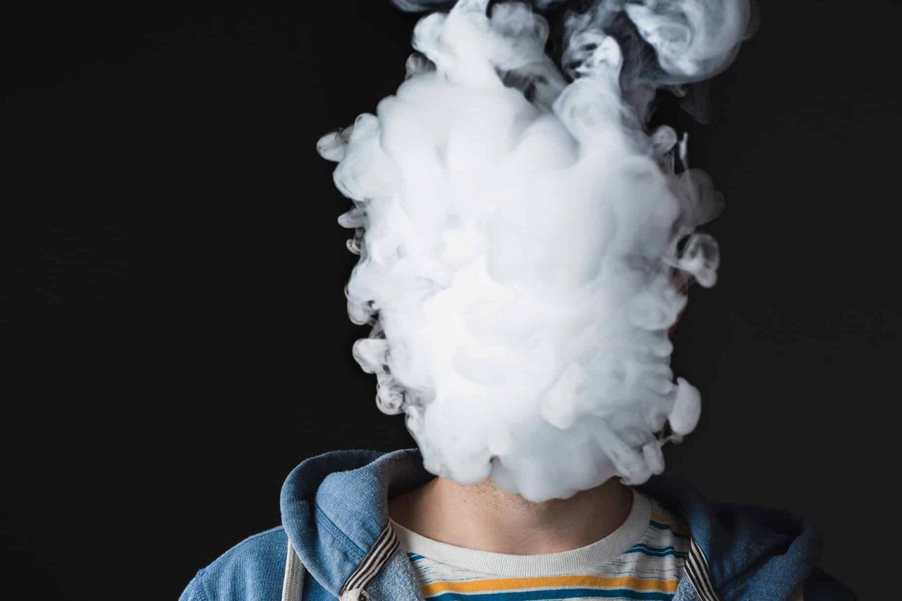 Persona con la cara oculta por una densa nube de vapor, que efectos tiene fumar un vaper sin nicotina descubre la verdad sobre el vaper zero