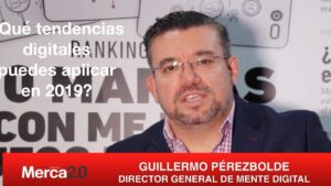 Hombre en entrevista frente a un banner de tendencias digitales hablando sobre que es el marketing automation plataformas