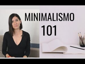 Mujer explicando que es el minimalismo en la vida diaria junto a un cuaderno y lápices sobre una mesa minimalista.