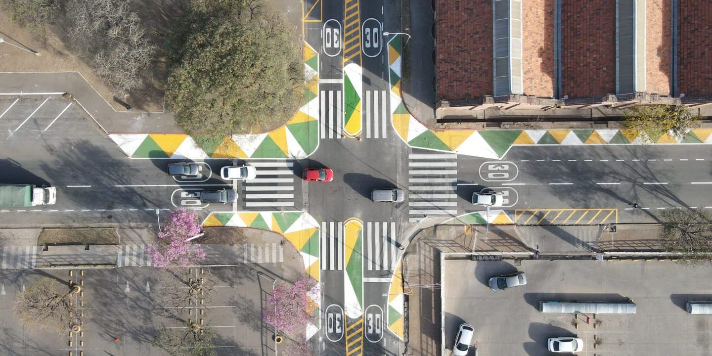 Vista aérea de una intersección urbana con pasos peatonales, marcas de velocidad y señalización colorida que es una interseccion vial y cual es su importancia en la seguridad vial 1