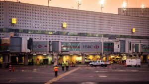 Personal de pista junto a pasarelas de embarque y vehículos de servicio en un aeropuerto al atardecer, que hacer aranda duero vacaciones inolvidables