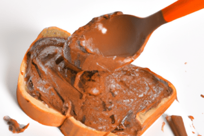 Tostada con crema de cacao untada con cuchara naranja que sugiere que hacer con la nutella caducada consejos y usos alternativos.