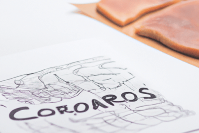 Hoja con garabatos y la palabra 'Corapos' sobre una superficie blanca junto a lonchas de carne cruda, Consejos prácticos que hacer si tienes carne caducada por 5 dias: guía visual y seguridad