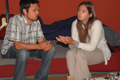 Pareja sentada en un sofá revisando documentos y conversando sobre que hacer si tu matricula esta caducada