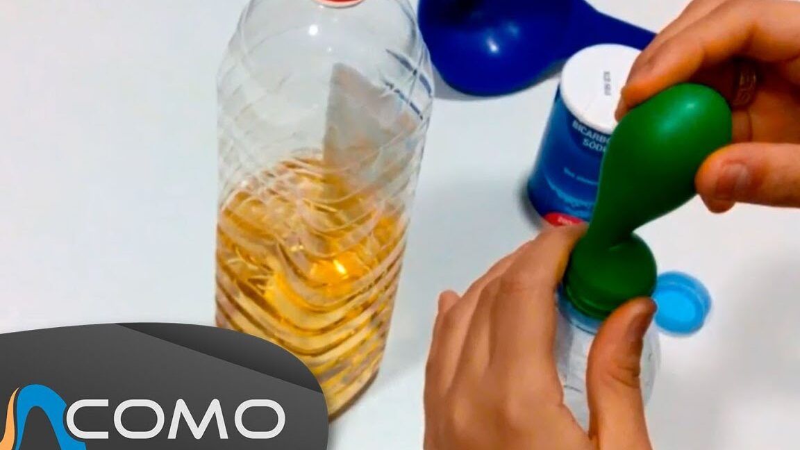 Manos colocando un globo sobre la boca de una botella con líquido rojizo junto a un frasco de bicarbonato, que ocurre al mezclar bicarbonato y vinagre rojo descubrelo aqui