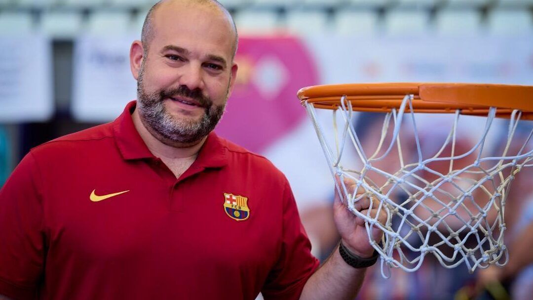 Hombre sonriente con camiseta roja del FC Barcelona junto a un aro de baloncesto, que pasa si ingreso 1000 euros en banco unicaja descubre aqui la respuesta.