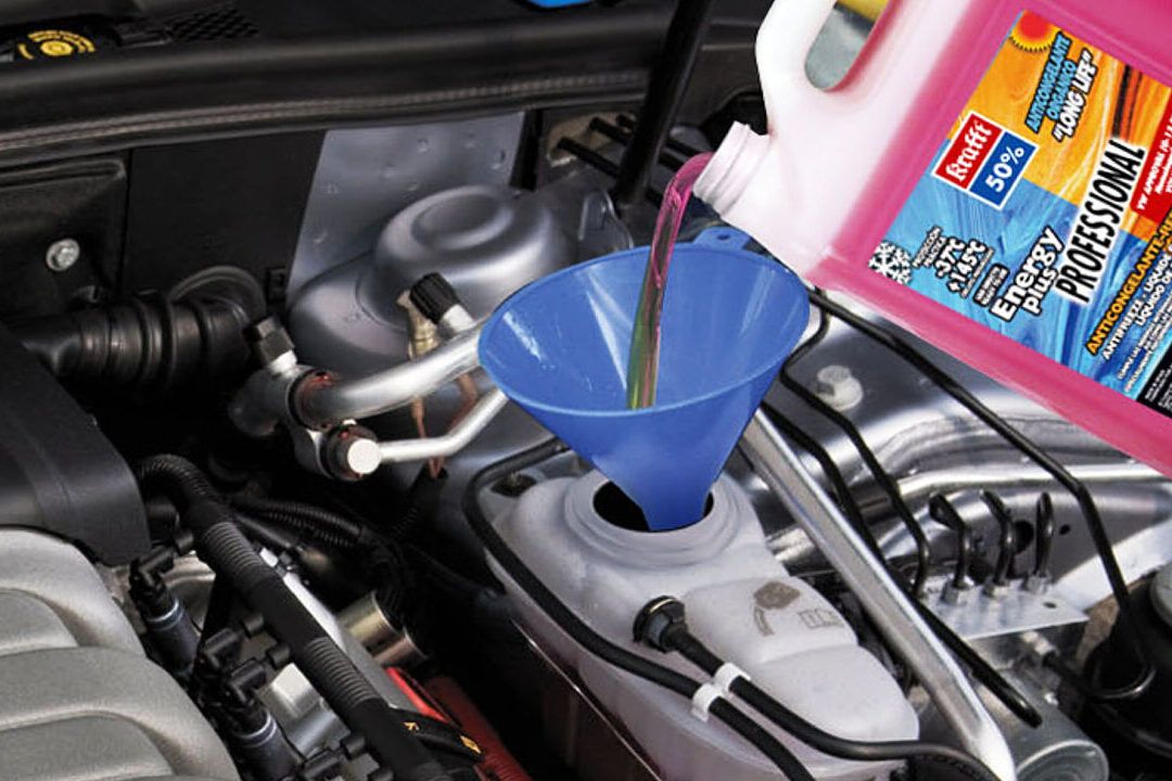 Que pasa si no tienes anticongelante en tu carro al ver cómo se vierte refrigerante rosa en el depósito del motor con un embudo azul