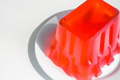 Gelatina roja parcialmente derretida en un plato blanco que pasa si una gelatina esta caducada 1