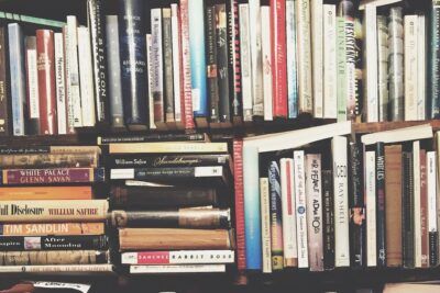 Estantería con libros apilados de distintos tamaños y colores que representa el emoji libro significado interpretacion.