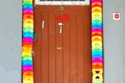 Puerta de madera adornada con guirnaldas multicolor y cartel 'Party Time', que representa el numero significado aqui