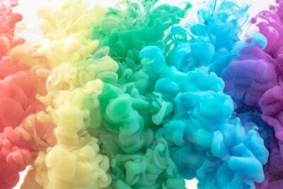 Nube abstracta de tinta en agua con tonos morado y azul que sugiere que significa color berenjena oscuro.