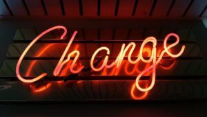 Letrero de neón naranja que dice 'Change', concepto visual para que significa hola en espanol.