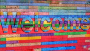 Mural de madera multicolor con la palabra Welcome que evoca que significa namaste en hindi como saludo de bienvenida