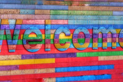 Mural de madera multicolor con la palabra Welcome que evoca que significa namaste en hindi como saludo de bienvenida