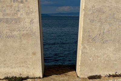 Dos pilastras de piedra con grabados náuticos frente al mar como metáfora de que significa no dar pie con bola.