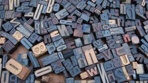 Montón de bloques de imprenta de madera y metal mostrando letras variadas que significa salut en rumano descubre su significado