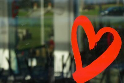 Corazón rojo pintado en vidrio que inspira búsquedas sobre que significa tatuaje corazon flecha brazo.