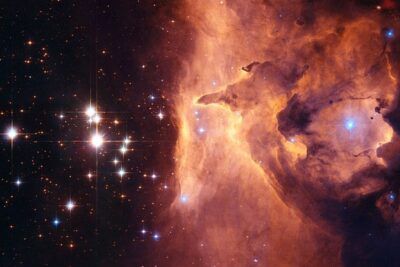 Nebulosa anaranjada con nubes de gas y estrellas brillantes que simboliza escorpio zodiaco significado caracteristicas en un cielo profundo