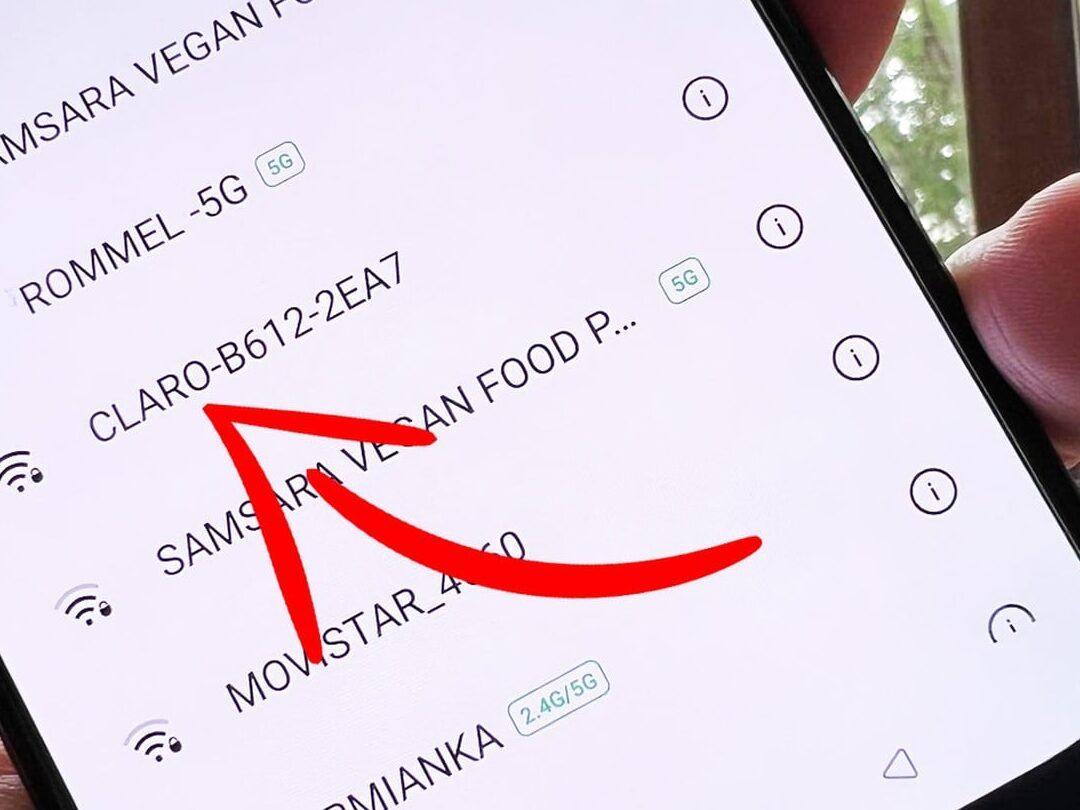 Móvil mostrando lista de redes WiFi con flecha roja señalando una entrada, explicación sobre que sucede al borrar un contacto de google en el telefono descubre las consecuencias.