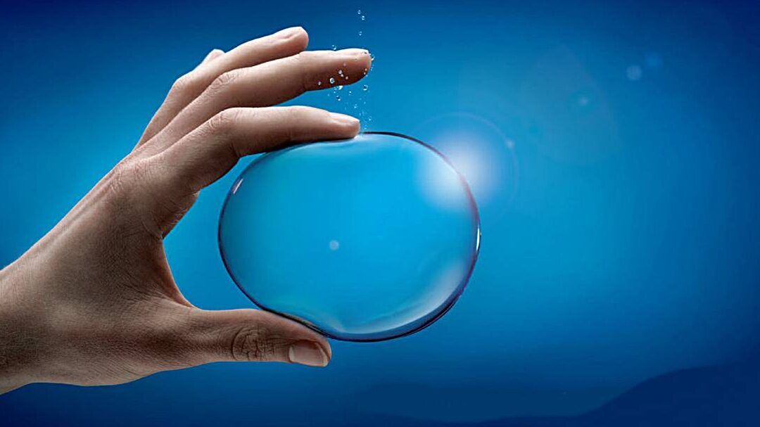 Mano que sostiene una burbuja transparente sobre un fondo azul brillante que evoca respiración y pureza, que sucede al inhalar gas de oxigeno descubre sus efectos