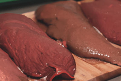 Trozo de carne cruda sobre tabla con cuchillo, inspección visual para que sucede si consumes carne 3 dias despues de su fecha de caducidad