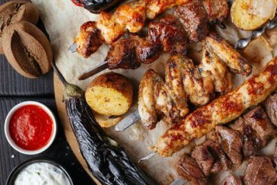 Tabla de brochetas, verduras asadas y salsas para acompañar receta autentica aji gallina peruano