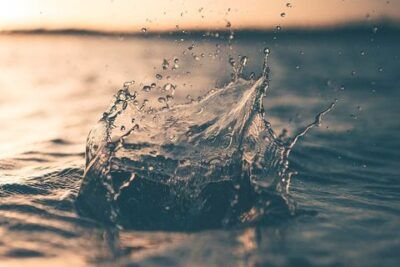 Salpicadura de agua en el mar al atardecer que ilustra el significado caer jarro agua fria