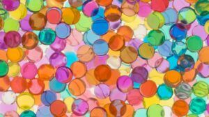 Plano detalle de perlas de gel translúcidas y coloridas con luz difusa significado color ambar oscuro profundo descubre simbolismo