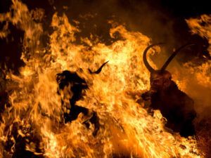 Escena nocturna de llamas voraces y siluetas con cuernos que evoca significado de sonar con incendio interpretacion y consejos.