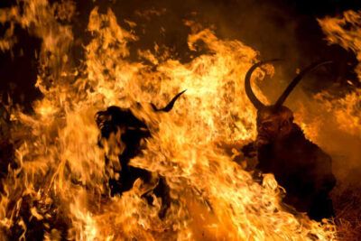 Escena nocturna de llamas voraces y siluetas con cuernos que evoca significado de sonar con incendio interpretacion y consejos.