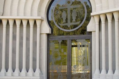 Fachada arqueada con puerta de vidrio y un ancla grabada en la ventana superior, significado del simbolo del ancla historia y mas 43 caracteres 1