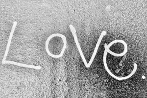 Grafiti blanco en pared texturizada que dice LOVE, significado hej sueco descubre palabra clave