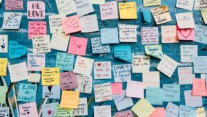 Muro de notas adhesivas manuscritas con mensajes de amor y apoyo, significado hello ingles traduccion guia completa