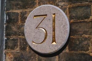 Placa circular de piedra con un número tallado en dorado que invita al significado numero descubre simbolismo misterio.