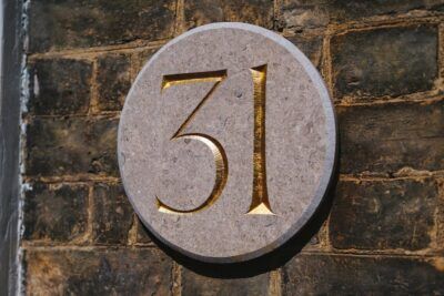 Placa circular de piedra con un número tallado en dorado que invita al significado numero descubre simbolismo misterio.