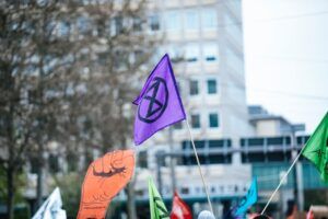 Banderas coloridas de protesta con símbolos y un puño en alto que transmiten energía y representan el significado sagitario astrologia