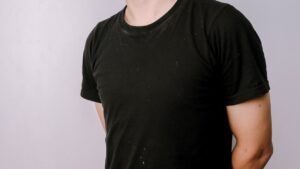 Torso con camiseta negra minimalista que refleja el significado ser pan comido y una estética sencilla