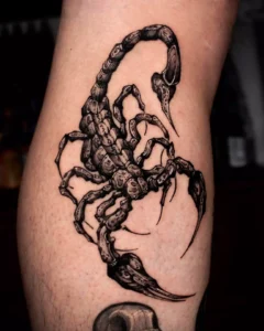 Tatuaje negro y sombreado de un escorpión en el antebrazo que invita a explorar el significado y simbolismo del tatuaje de escorpion en la muneca.